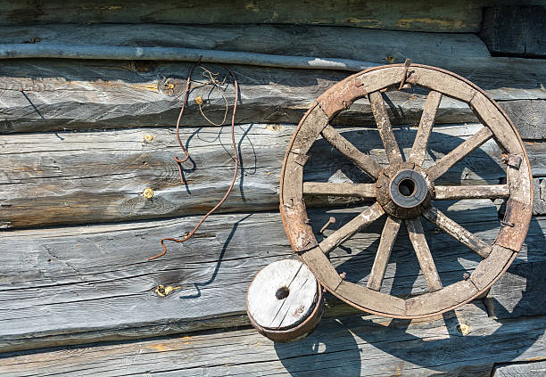 istock Wooden wheel on the log wall. 480764256