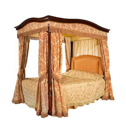 Old vintage four poster bed with drapes and curtains isolated on white with clipping path