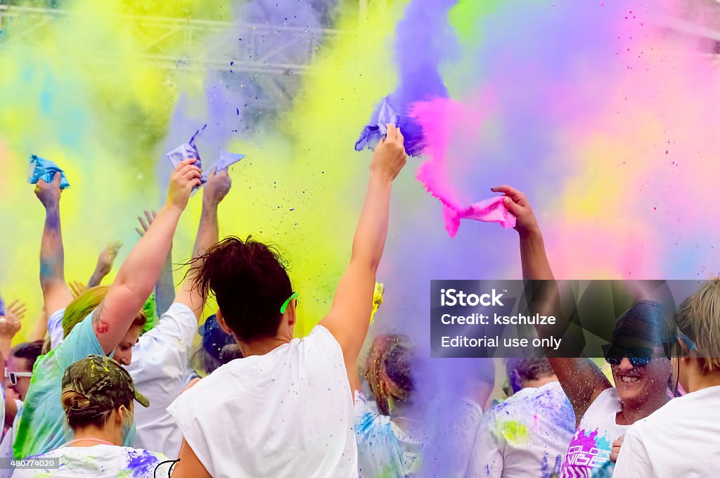 Celebration of color with a powder throw Peoria, Illinois, USA - July 11, 2015: Revelers release packets of starchy powder into the air, creating drifting clouds of color, in anticipation of a 5K "fun run" in this city on the Illinois River. 20-29 Years Stock Photo