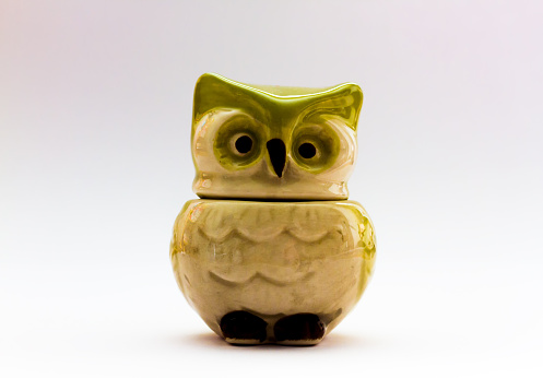 A vintage mid century modern kitchen measuring cup shaped like a green and white owl.