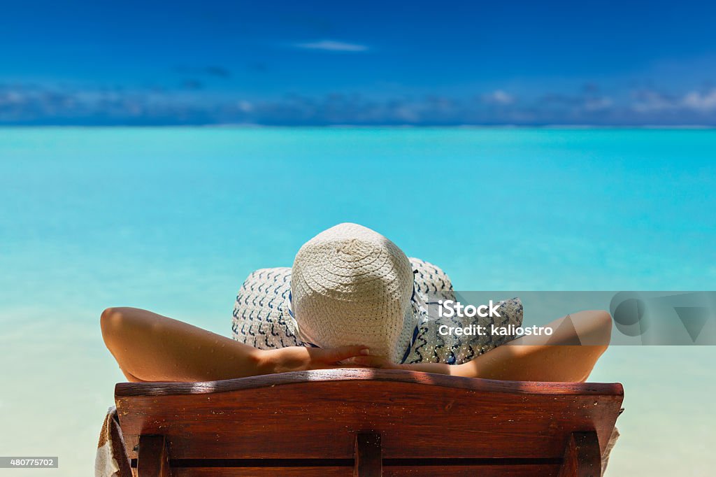 Paradise on the Caribbean Bahamas Maldivian Hawaiian beaches girl lays on a chaise lounge in the back on the banks of the turquoise Caribbean sea on Bahamian Maldivian Hawaiian beaches 2015 Stock Photo