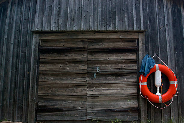 Red life ring hanging on old wooden garage