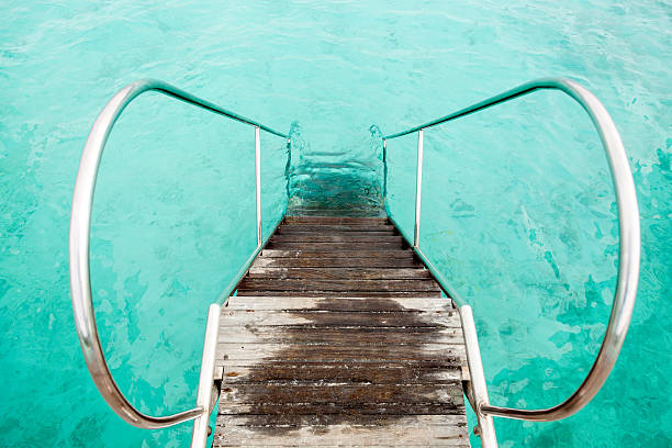 old wooden ladder descending into the turquoise Caribbean Sea, Hawaii Bahamas Maldives