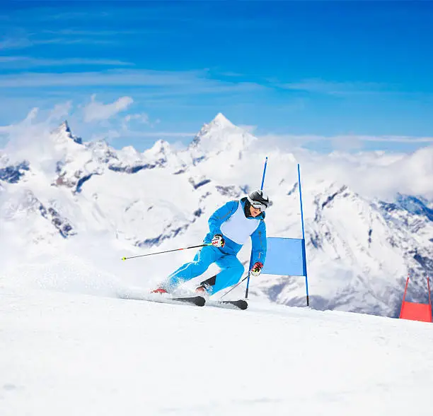 Giant slalom race. Senior man skier, snow skiing carving at high speed. A beautiful snowy mountain landscape in the background. Switzerland Zermatt region, mountain Matterhorn