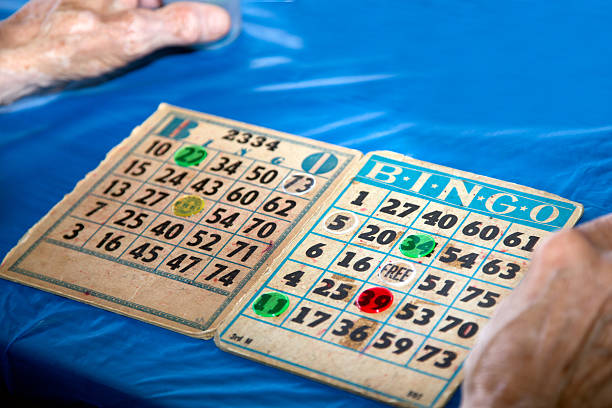 Bingo Cards Close-Up with Hands This classic game of chance is a favorite that can make anyone a winner! free bingo stock pictures, royalty-free photos & images