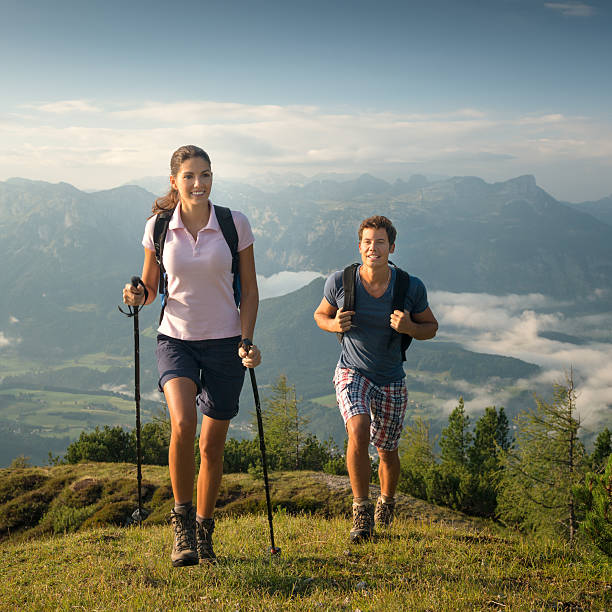 A mature man is hiking surrounding by a beautiful landscape of the Swiss Mountains in summer. This picture is taken in Zinal, Val d'Anniviers, Canton of Valais. Copy space
