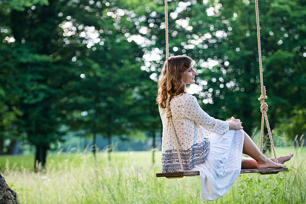 istock Young Beautiful Woman On A Swing 480789204