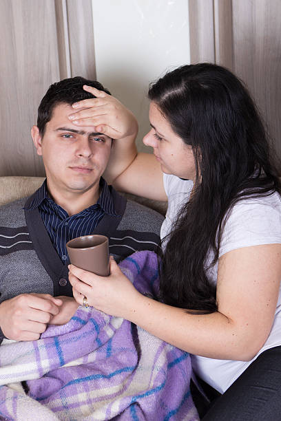 istock Wife helping her sick husband with flu 480793517