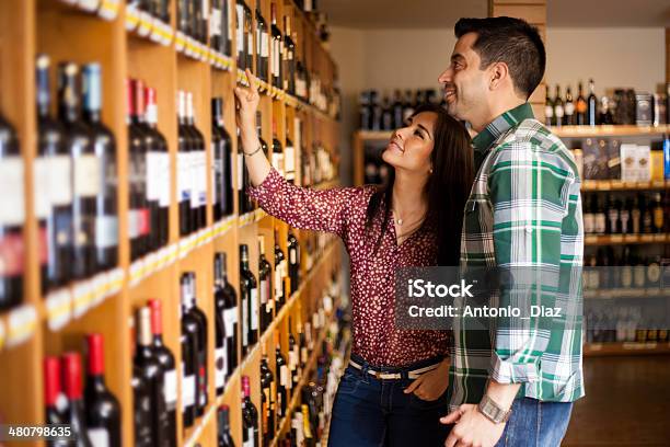 Picking Up Some Wine At The Store Stock Photo - Download Image Now - Wine, Shopping, Wine Bottle