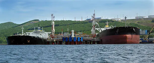 two tankers are in port under loading of oil