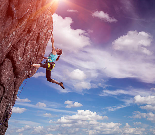 climber appesi sulla sua mano - climbing rock climbing women mountain climbing foto e immagini stock