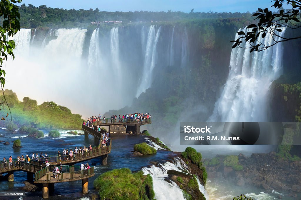 Tourists at Iguazu Falls, Foz do Iguacu, Brazil Tourists at Iguazu Falls, one of the world's great natural wonders, near the border of Argentina and Brazil. Iguacu Falls Stock Photo