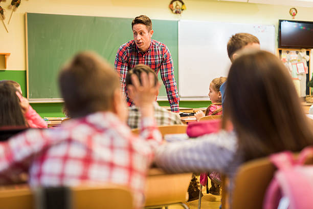 istock Elementary male teacher teaching children in the classroom. 480803616