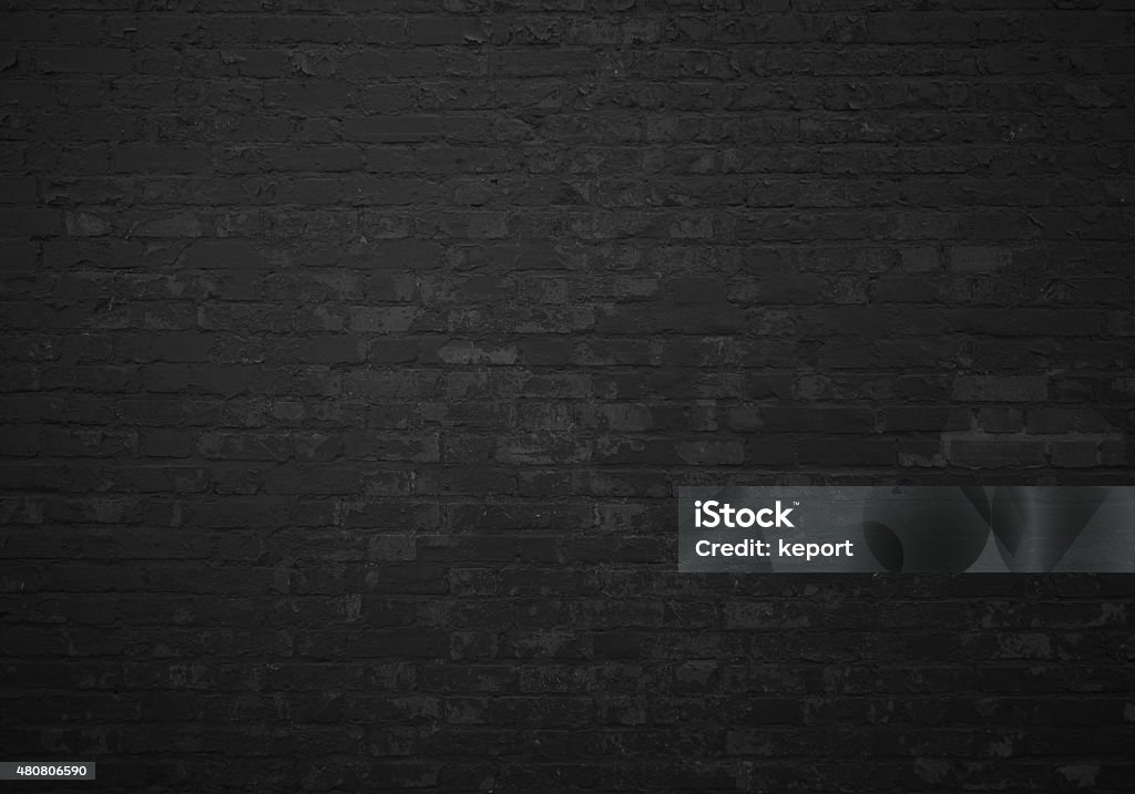 Old brick wall with black stones Background of an old brick wall with black stones Brick Stock Photo