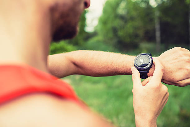 corredora olhando relógio esportivo check-in - gps watch - fotografias e filmes do acervo