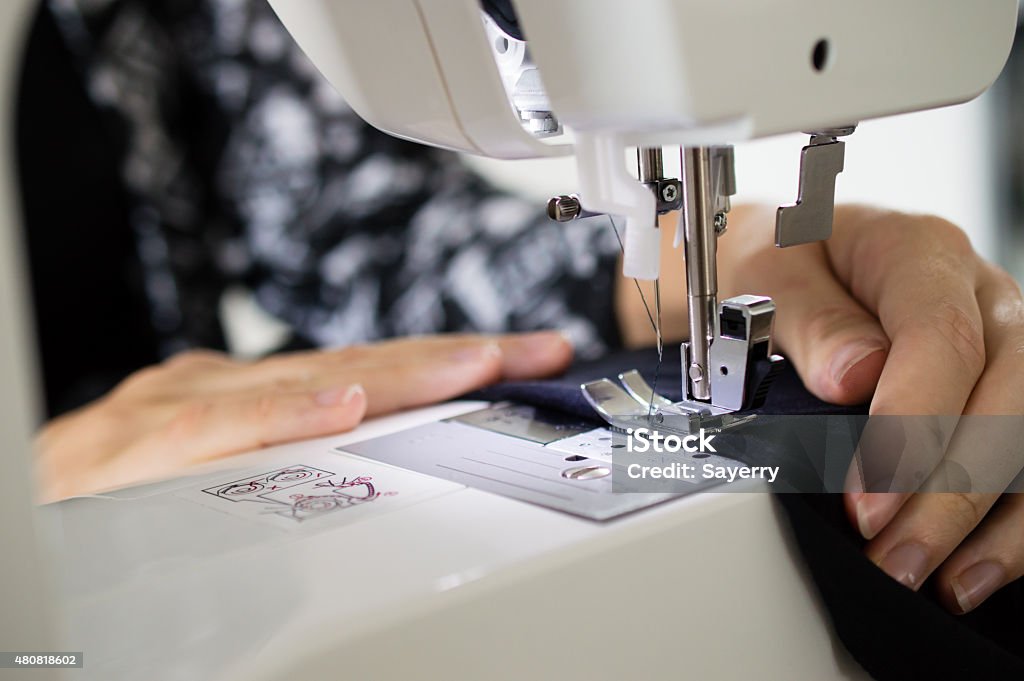 sewing close up shot of hands using sewing machine Change Stock Photo