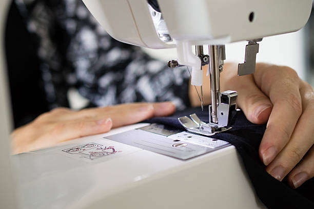 sewing close up shot of hands using sewing machine sewing machine stock pictures, royalty-free photos & images