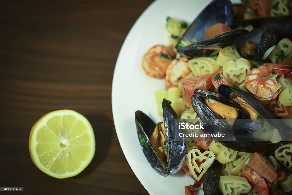 Pasta with mussels and cherry tomatoes Heart shaped pasta with mussels, shrimps and cherry tomatoes Animal Shell Stock Photo