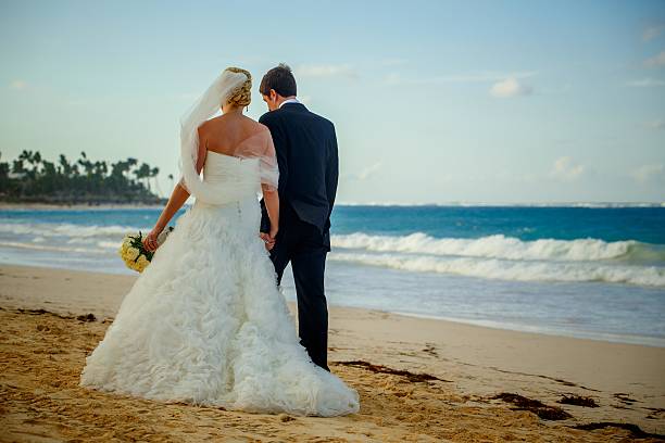 istock Bride and Groom walk on the beach 480834699