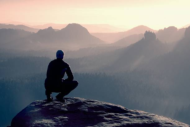 istock Young man in black sportswear is sitting on cliff's edge 480834858
