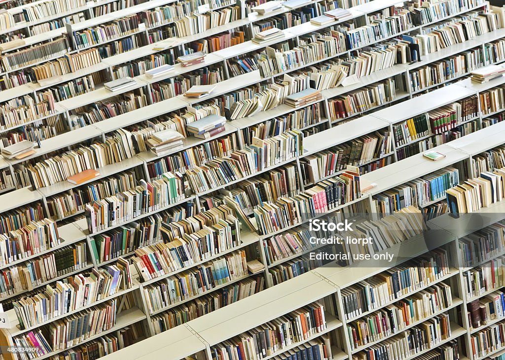 Righe di libri in una biblioteca pubblica - Foto stock royalty-free di Imparare