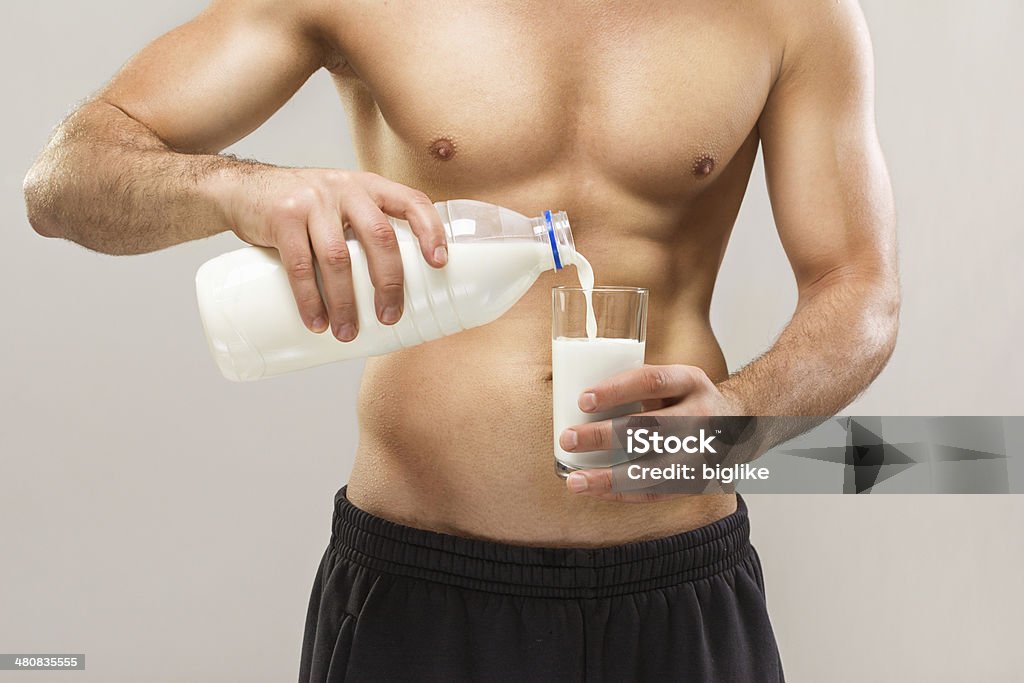 Verter la leche en primer plano de hombre - Foto de stock de Abdomen libre de derechos