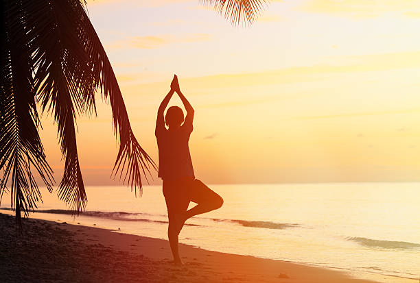 istock Silhouette of young man meditating at sunset 480838140