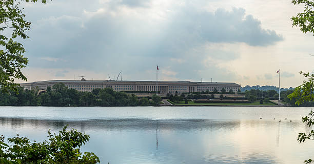 The Pentagon The Pentagon, headquarters of the Department of Defense, behind and reflected in the Pentagon Lagoon Yacht Basin with storm clouds developing in the sky  and the sun's rays peeking through. arlington virginia photos stock pictures, royalty-free photos & images