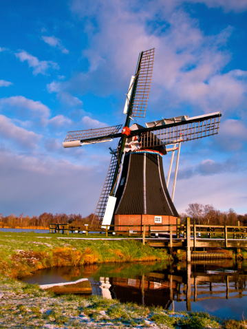 Dutch Windmill on the Waterfront of a Lake with Spectacular Clouds