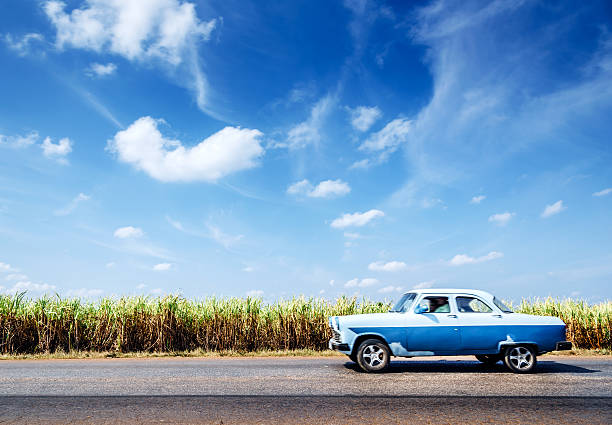 Vintage car driving on rural road, Cuba
