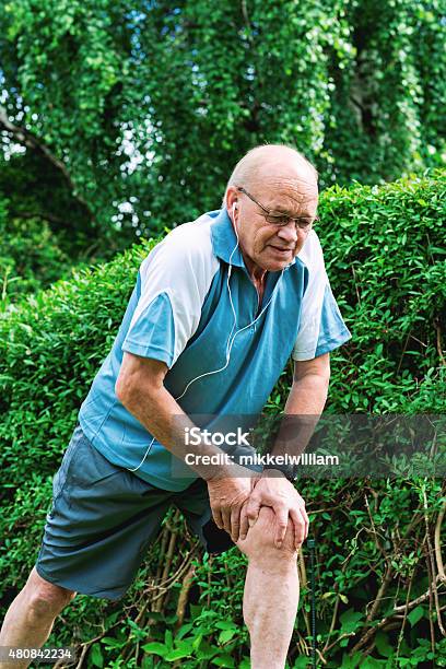 Senior Runner Stretches His Legs Before Going On A Run Stock Photo - Download Image Now