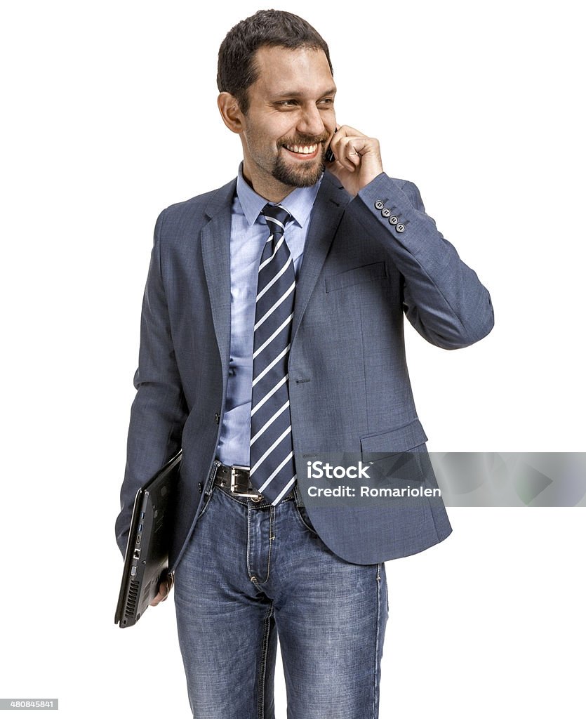 Smiling businessman talking on the phone - isolated young man in an expensive suit with a folder in his hand talking on the phone - isolated on white background Adult Stock Photo