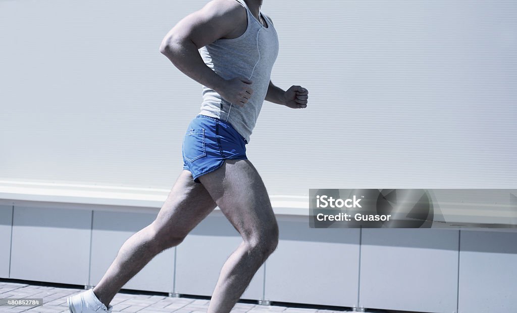 Sport, workout and healthy lifestyle concept - sporty fitness ma Sport, workout and healthy lifestyle concept - sporty fitness man running in the city, male runner working outdoors 2015 Stock Photo