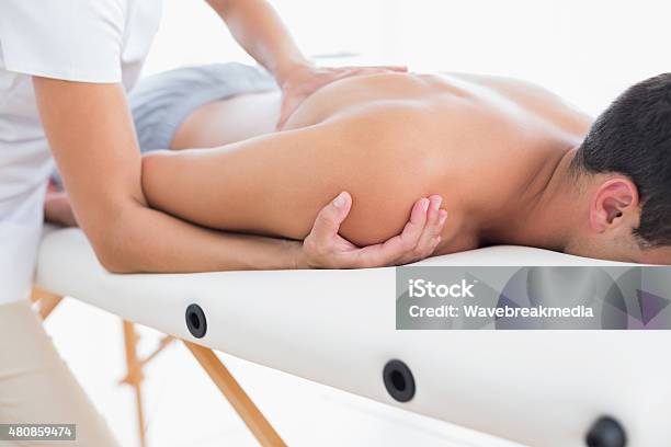 Physiotherapist Doing Shoulder Massage To Her Patient Stock Photo - Download Image Now