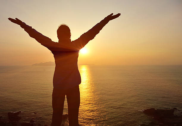 istock cheering woman sunrise seaside 480864331