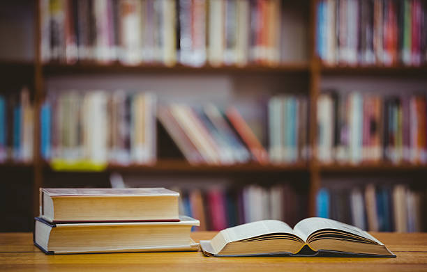 Books on desk in library stock photo