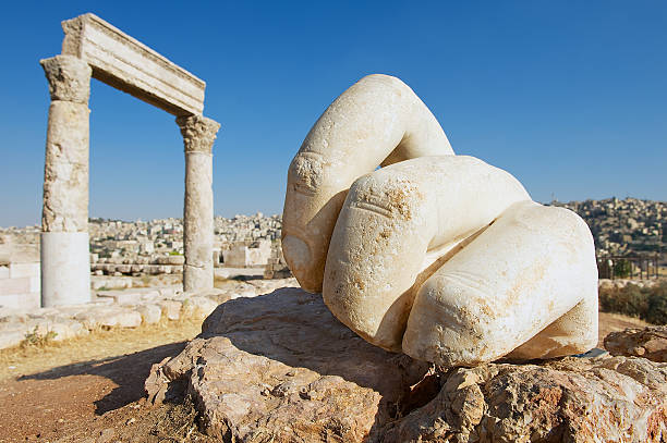 Stone Hercules hand at the antique Citadel in Amman, Jordan. Stone Hercules hand at the antique Citadel in Amman, Jordan. At the background: ruins of the Hercules temple and Amman city. amman pictures stock pictures, royalty-free photos & images