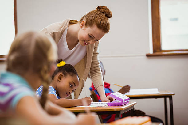 istock Teacher helping a little girl during class 480868424