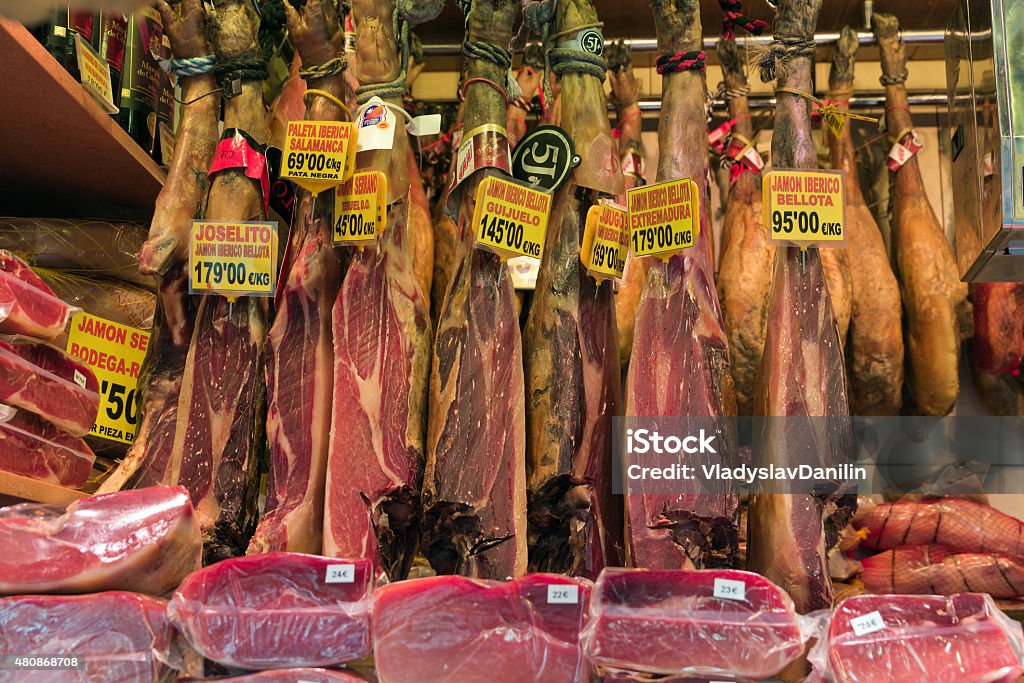 Spanish ham cellar Set leg of spanish serrano ham assortment ready for the hungry consumer. The Boqueria world famous market in Barcelona 2015 Stock Photo