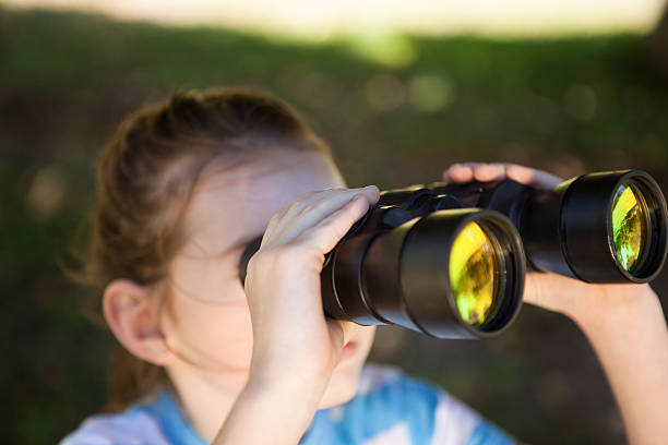 istock Cute little girl looking through binoculars 480868894