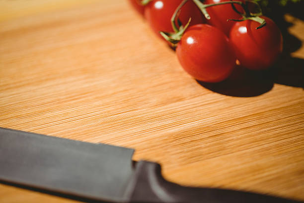 istock Cherry tomatoes and knife on chopping board 480872178