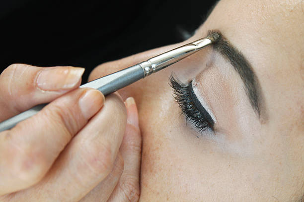 istock Makeup artist tracing eye line with black eyeliner 480873046