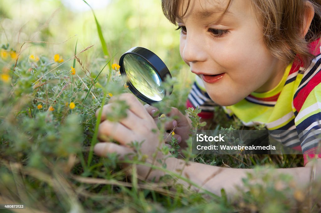 Happy little boy looking a través de lupa - Foto de stock de Niño libre de derechos