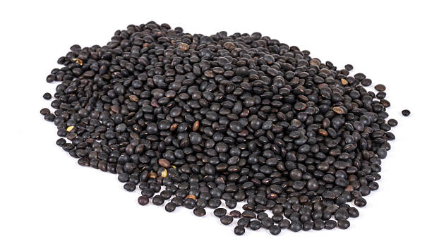 istock Heap of black lentil isolated on white 480874081
