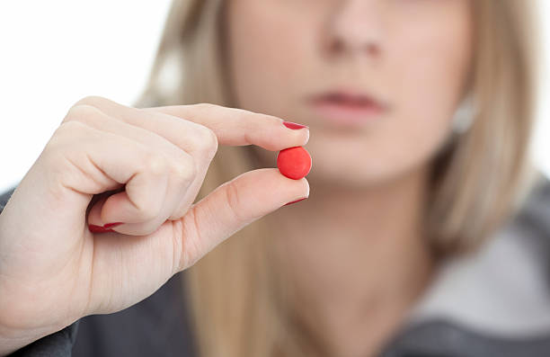 istock young girl holding a pill 480879589