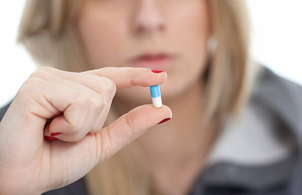 istock young girl holding a pill 480879667