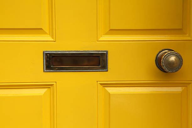 yellow door with letterbox and doorknob stock photo