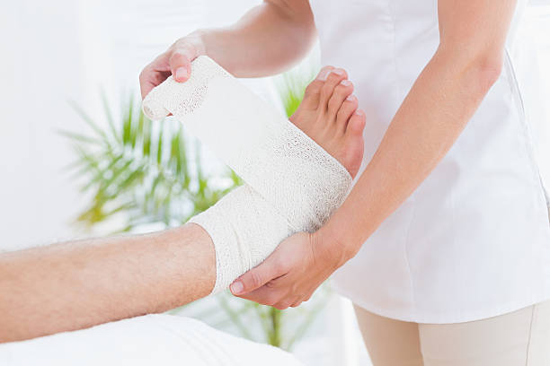 istock Doctor bandaging her patient ankle 480885762