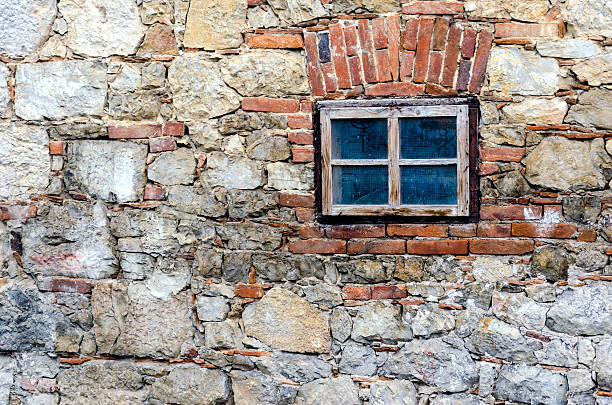 Small window on a stone wall stock photo