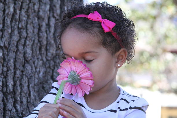 istock Young girl sniffing pink flower 480892765